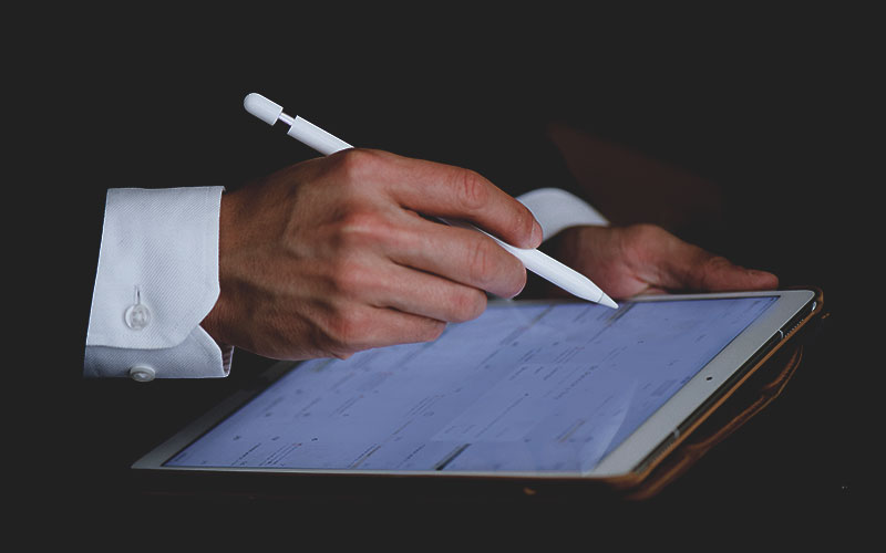 Hand using stylus on a tablet. Hand using stylus on a tablet.