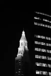 Clock tower and modern building at night.